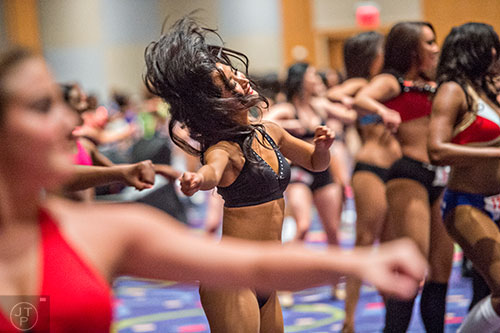 Azusa Hashizame (center) runs through her dance routine before first cut tryouts begin for the Atlanta Falcons Cheerleaders at the Georgia International Convention Center in Atlanta on Sunday, May 3, 2015. 
