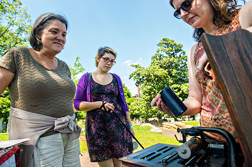 Nancy Christensen (left) and Sarah Padgett talk to April Ledbetter about the Dust-to-Digital Sound System installation during the Arts at Oakland presents Roam Transmissions' The Cryptophonic Tour at Oakland Cemetery in Atlanta on Saturday, May 2, 2015. 