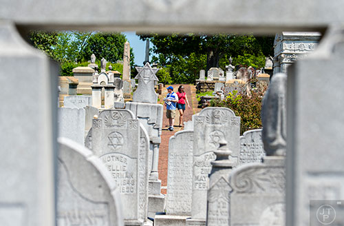 Josh Rothburd (left) and Ellen Cohen walk past grave stones during the Arts at Oakland presents Roam Transmissions' The Cryptophonic Tour at Oakland Cemetery in Atlanta on Saturday, May 2, 2015. 
