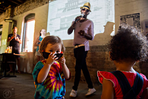 Avery Aniskiewicz (left) and Joyelle Williams dance as David Williams from WERD Radio sings during the Fire in the Fourth Festival in the Old Fourth Ward neighborhood of Atlanta on Saturday, May 2, 2015. 