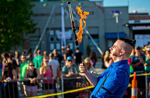 Cosmo Franz tosses a flaming torch in the air during the Fire in the Fourth Festival in the Old Fourth Ward neighborhood of Atlanta on Saturday, May 2, 2015. 