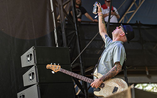 Flogging Molly's Nathen Maxwell lifts a beer towards the crowd as he takes the stage during the Shaky Knees Music Festival at Central Park in Atlanta on Saturday, May 9, 2015. 