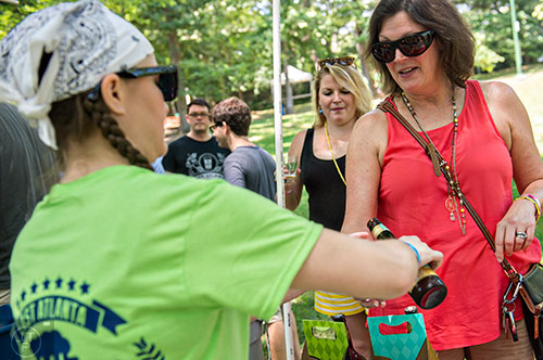 Cathy Towles (right) and her daughter Eleanor get a fresh beer from Tammi Ryan during the East Atlanta Beer Fest at Brownwood Park on Saturday, May 16, 2015. 