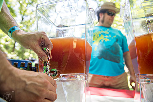Dan Hourigan (hands) pours a mixture of Fourth Ward Distillery vodka, SweetWater Blue, lemon and bitters for Karl Harden during the East Atlanta Beer Fest at Brownwood Park on Saturday, May 16, 2015. 