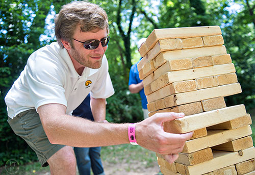 Josh Geter plays an oversized game of Jenga during the East Atlanta Beer Fest at Brownwood Park on Saturday, May 16, 2015. 