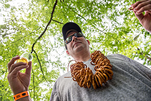 Rob Malacrea wears a necklace of pretzels as he samples beer during the East Atlanta Beer Fest at Brownwood Park on Saturday, May 16, 2015.