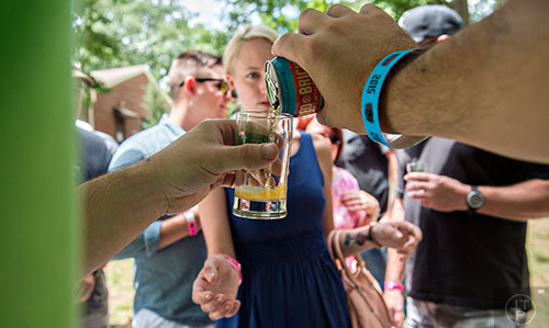 Matt Warenzak (hands) pours a beer for Ashley Ackerman during the East Atlanta Beer Fest at Brownwood Park on Saturday, May 16, 2015. 