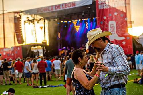 Brandon Bernard (right) dances with Edee Biddlecome as the sun sets during the Shaky Boots Music Festival at Kennesaw State University on Sunday, May 17, 2015. 