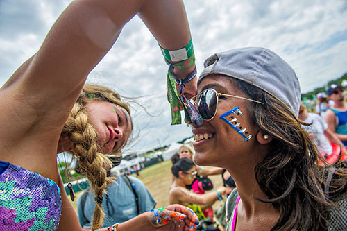 Bhumika Patel (right) has her face painted by Chandler Fritts during the CounterPoint Festival at Kingston Downs in Rome on Sunday, May 24, 2015. 