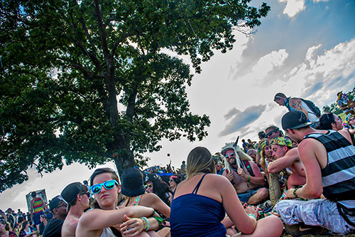 Corey Hollingsworth (right center) take shade from the sun underneath a tree during the CounterPoint Festival at Kingston Downs in Rome on Sunday, May 24, 2015. 