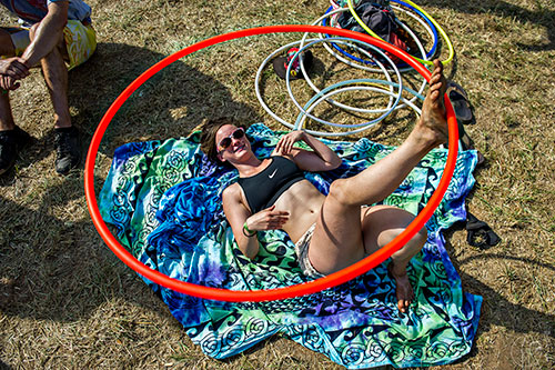 Hassie Beth Bigbie lays on the ground as she hula hoops with her foot during the CounterPoint Festival at Kingston Downs in Rome on Sunday, May 24, 2015. 