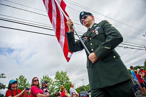 Terry Thomas carries an American flag down Dacula Rd. during the annual Dacula Memorial Day Parade on Monday, May 25, 2015. 