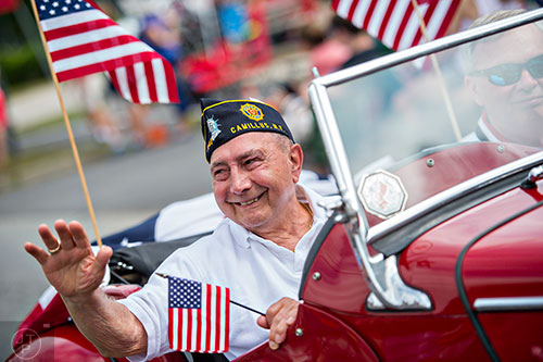 WWII veteran Rocco Fiermonte waves to the crowd during the annual Dacula Memorial Day Parade on Monday, May 25, 2015. 