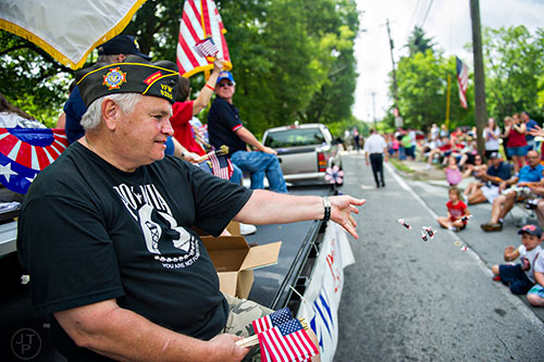 Larry Loper (left) throws candy to the crowd during the annual Dacula Memorial Day Parade on Monday, May 25, 2015.