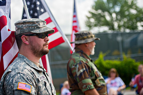 Josh Reynolds (left) and Donald Mize carry American flags down the parade route during the annual Dacula Memorial Day Parade on Monday, May 25, 2015. 