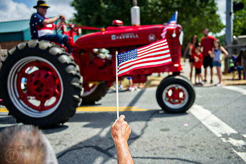 John Seymour waves an American flag during the annual Dacula Memorial Day Parade on Monday, May 25, 2015. 