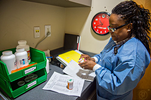 Dr. Katrina Schuler-Bacon fills a prescription for one of her patients at Mercy Care's dental clinic off of Decatur St. in Atlanta on Tuesday, May 19, 2015. 