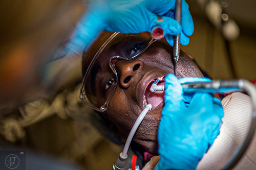 Cedric Russell (right) has his teeth cleaned by dental hygenist Cindy Pickard during a visit to Mercy Care's dental clinic at their facility off of Decatur St. in Atlanta on Tuesday, May 19, 2015. 