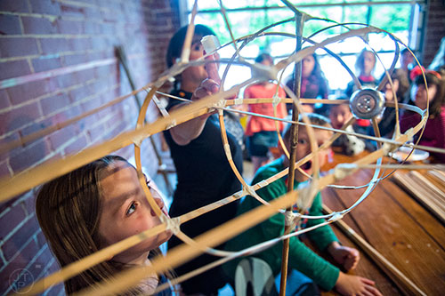 Skylar Marks (left) looks at a fish shaped bamboo lantern during a workshop at Color Wheel Studio in Decatur on Friday, April 24, 2015. 