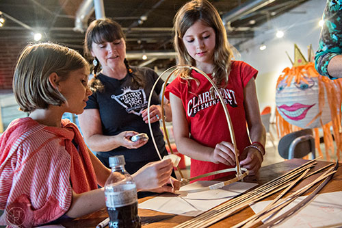 Eva Cobb (left) and Lily Keeler (right) get help with their bamboo lantern from Chantelle Rytter during a workshop at Color Wheel Studio in Decatur on Friday, April 24, 2015. 