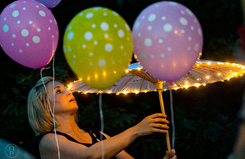 Kelly Hackett checks the lights on her umbrella before the start of the Decatur Lantern Parade on Friday, May 15, 2015.