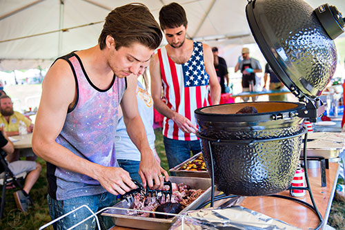 Andrew Desrosiers (left) shreds barbeque that he and Michael LaMont cooked in the barbeque competition during the Kirkwood Spring Fling at Bessie Branham Park on Saturday, May 16, 2015.
