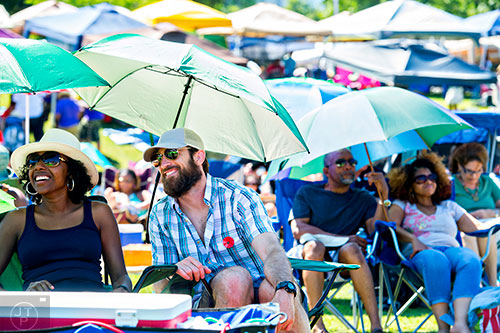 Sienna Taylor (left) and Jamie Lytle find shade from the sun underneath their umbrella as they watch bands perform on the main stage during the Atlanta Jazz Fest at Piedmont Park on Saturday, May 23, 2015.