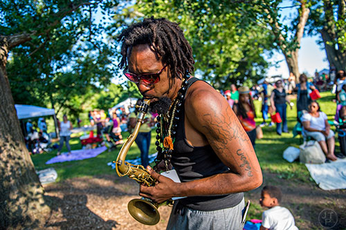 Kebbi Williams (center) plays his saxophone while walking through the crowd during the Atlanta Jazz Fest at Piedmont Park on Saturday, May 23, 2015.