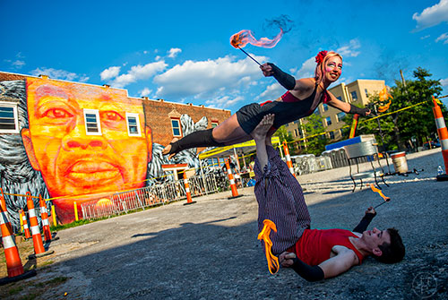 Charlotte Dillard balances on Zac Ogilvie's feet as they perform with fire during the Fire in the Fourth Festival in the Old Fourth Ward neighborhood of Atlanta on Saturday, May 2, 2015.