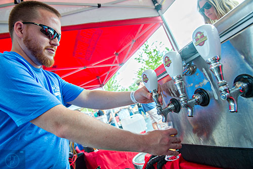 Nate Watkins pours a fresh beer from Wild Heaven during the Georgia Craft Beer Festival outside of Red Brick Brewing in Atlanta on Saturday, May 30, 2015. 