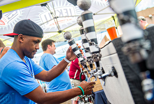 CJ Cypress pours a fresh beer from Jailhouse Brewing during the Georgia Craft Beer Festival outside of Red Brick Brewing in Atlanta on Saturday, May 30, 2015. 