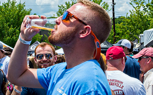 Greg Ranallo (left) smiles as he waits in line for his next beer during the Georgia Craft Beer Festival outside of Red Brick Brewing in Atlanta on Saturday, May 30, 2015. 