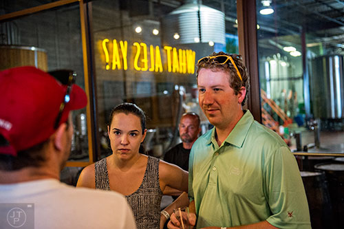 Michael Tallini (right) and Jenna Settle take a break from the heat as they talk with friends inside of Red Brick Brewing's tasting room during the Georgia Craft Beer Festival in Atlanta on Saturday, May 30, 2015. 
