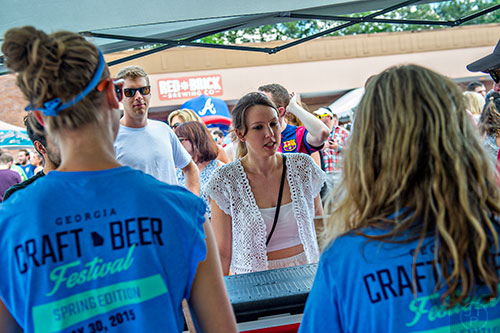 Lauren Mullen (center) decides which beer to try during the Georgia Craft Beer Festival outside of Red Brick Brewing in Atlanta on Saturday, May 30, 2015. 