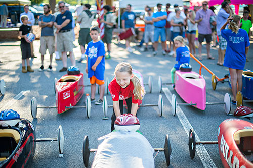 Kimberly Brown (center) stops her car from rolling back during the driver meeting before the start of the All American Dunwoody Soap Box Derby at the First Baptist Church of Atlanta in Dunwoody on Saturday, June 6, 2015. 