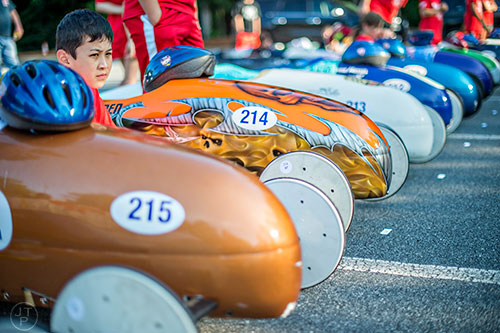 Lander Schultz (left) sits next to his car before the start of the All American Dunwoody Soap Box Derby at the First Baptist Church of Atlanta in Dunwoody on Saturday, June 6, 2015.
