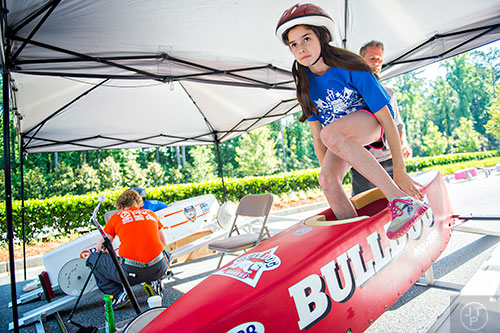 Alexys Grivakis (right) climbs into her car during the All American Dunwoody Soap Box Derby at the First Baptist Church of Atlanta in Dunwoody on Saturday, June 6, 2015.