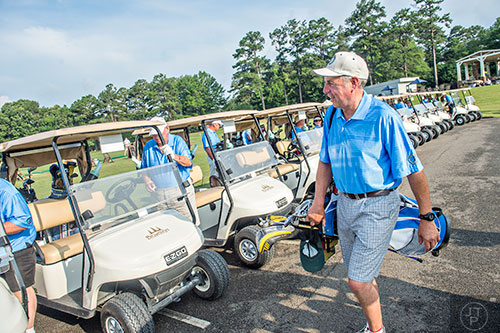 Bobby "Rhyl" Jones (right) from Yorkshire, England carries his clubs to his cart before the start of the Bobby Jones Open golf tournament at Braelinn Golf Club in Peachtree City on Tuesday, June 9, 2015. 