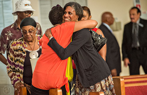 Alexis Balkum (center) greets Dr. Cheryl Jordan with a hug before the start of the Prayer, Healing and Reconciliation Service for members of the Emanuel A.M.E. Church in Charleston, South Carolina who lost their lives earlier this week at Big Bethel A.M.E. Church in Atlanta on Friday, June 19, 2015.   