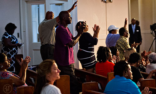 Kim King (center) stands and claps during the Prayer, Healing and Reconciliation Service for members of the Emanuel A.M.E. Church in Charleston, South Carolina who lost their lives earlier this week at Big Bethel A.M.E. Church in Atlanta on Friday, June 19, 2015. 