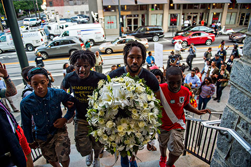 James Campbell (center) carries a wreath of flowers into the Prayer, Healing and Reconciliation Service for members of the Emanuel A.M.E. Church in Charleston, South Carolina who lost their lives earlier this week at Big Bethel A.M.E. Church in Atlanta on Friday, June 19, 2015. 