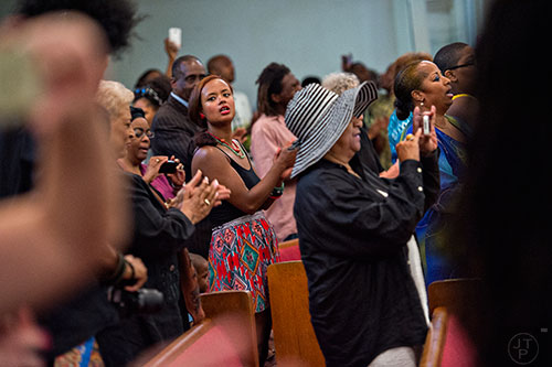 Stacy Epps (center) claps as people sing during the Prayer, Healing and Reconciliation Service for members of the Emanuel A.M.E. Church in Charleston, South Carolina who lost their lives earlier this week at Big Bethel A.M.E. Church in Atlanta on Friday, June 19, 2015. 