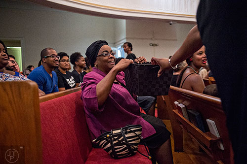Dr. Shirley White (center) puts a donation into the offering basket during the Prayer, Healing and Reconciliation Service for members of the Emanuel A.M.E. Church in Charleston, South Carolina who lost their lives earlier this week at Big Bethel A.M.E. Church in Atlanta on Friday, June 19, 2015. Money was collected during the service to send to the families of the victims. 