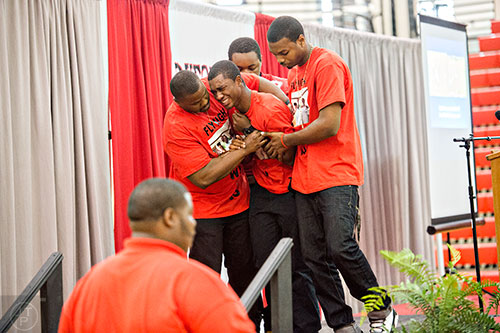 Andre Grimsley (center) is carried off stage by friends as he tries to speak during Wali Clanton Jr's. memorial service at Dutchtown High School in Hampton on Thursday, June 18, 2015. 