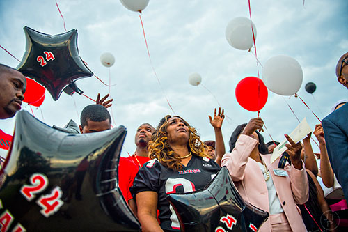 Latoscha Brown (center) watches as balloons are released in honor of her son at the conclusion of the services for Wali Clanton Jr. at Dutchtown High School in Hampton on Thursday, June 18, 2015. 