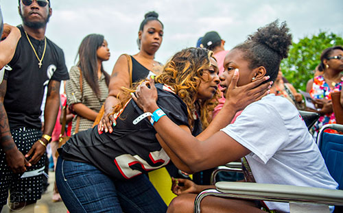 Latoscha Brown (center) hugs Maiya Dowdell (right) at the conclusion of the services for Wali Clanton Jr. at Dutchtown High School in Hampton on Thursday, June 18, 2015. Dowdell is recovering from injuries sustained from the same pool party that turned violent where Clanton Jr. lost his life.  