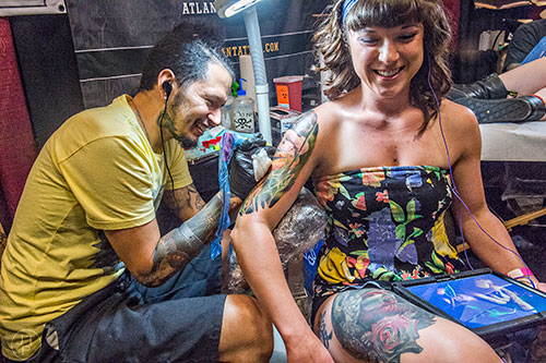 Oscar Zornosa (left) adds color to a snake tattoo for Jordan Galehan during the 19th annual Atlanta Tattoo Expo at the Wyndham Atlanta Galleria hotel on Saturday, June 20, 2015. 