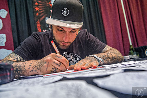 Mattia D'Attardi sketches tattoo designs as he waits for a client during the 19th annual Atlanta Tattoo Expo at the Wyndham Atlanta Galleria hotel on Saturday, June 20, 2015. 