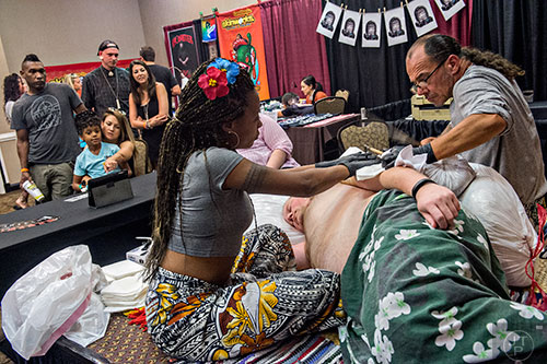 Sulu' Ape Pili Mo'o (right) works on a traditional tattoo for Matt Howard with the help of Penina Samo'o during the 19th annual Atlanta Tattoo Expo at the Wyndham Atlanta Galleria hotel on Saturday, June 20, 2015. 