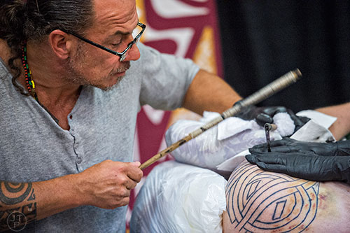 Sulu' Ape Pili Mo'o (left) works on a traditional tattoo for Matt Howard during the 19th annual Atlanta Tattoo Expo at the Wyndham Atlanta Galleria hotel on Saturday, June 20, 2015. 